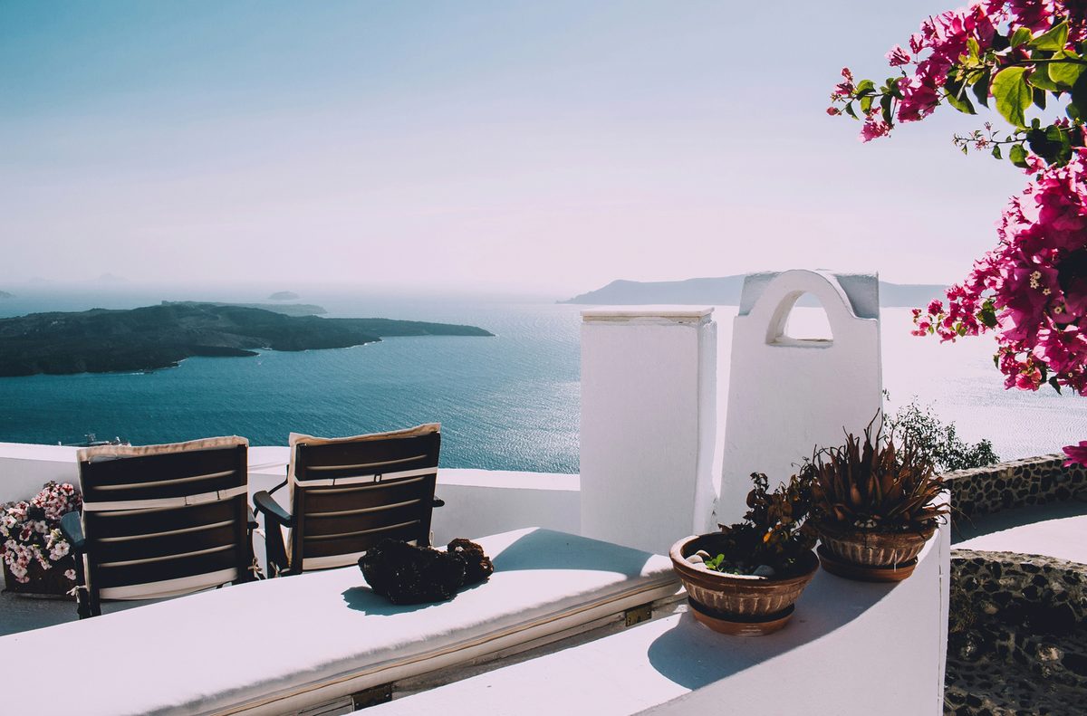 A whitewashed terrace in Santorini overlooking the blue Aegean Sea